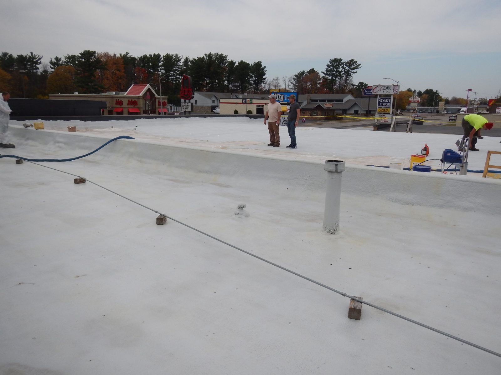 Commercial metal roof being waterproofed with seamless polyurea membrane